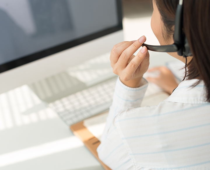 woman on computer talking on headset 