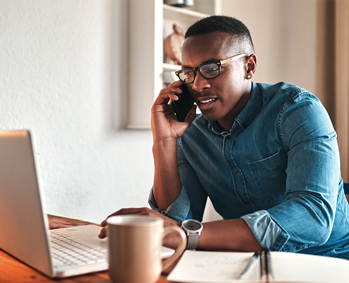 man on the phone at his computer